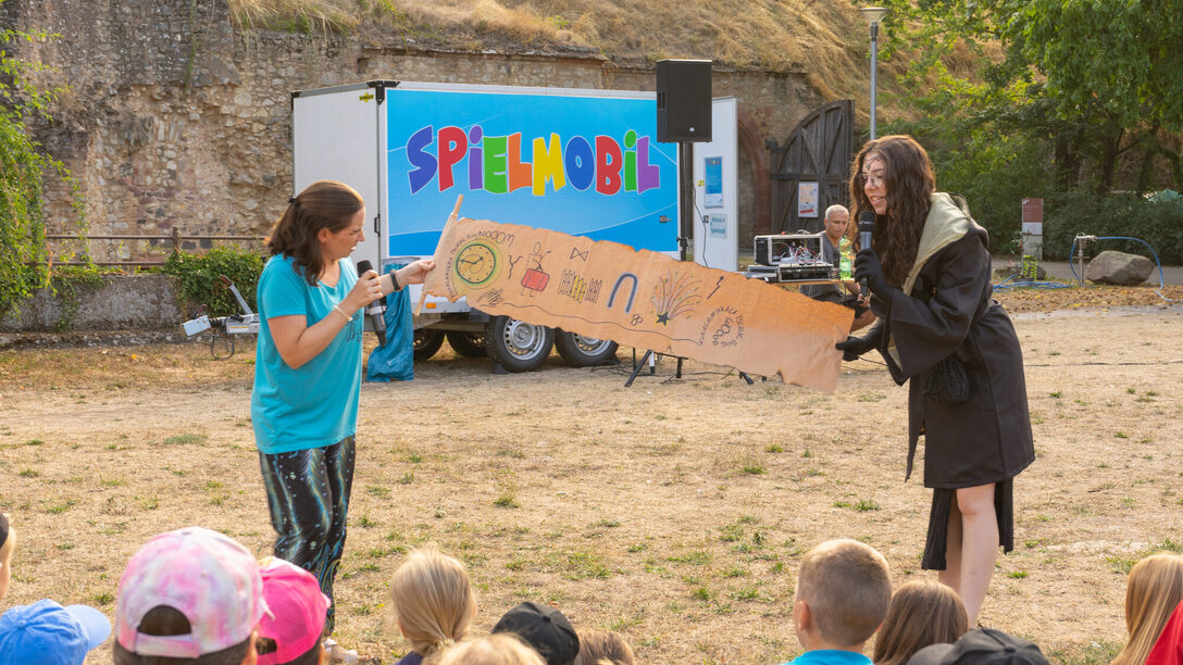 Zwei Mitarbeiterinnen der Jugendförderung eröffnen mit zahlreichen Kindern im Festungsgraben die Rüsselsheimer Ferienspiele