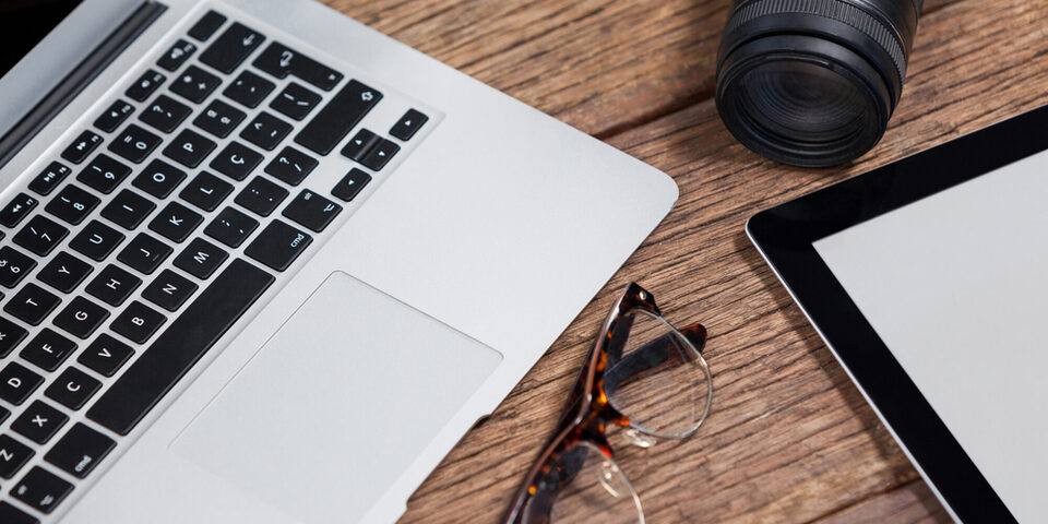 Close-up of digital camera, digital tablet, laptop, spectacle on table